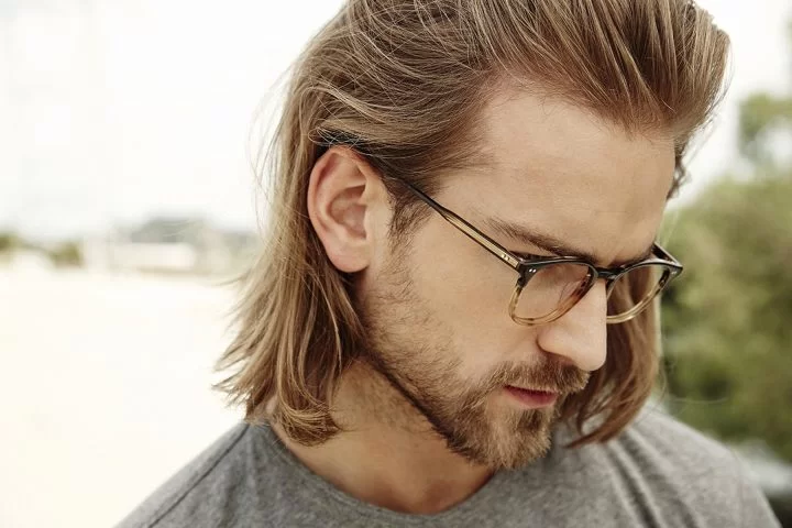 Brillenmarke Garrett Leight - Mann mit Brille, langen Haaren und Bart