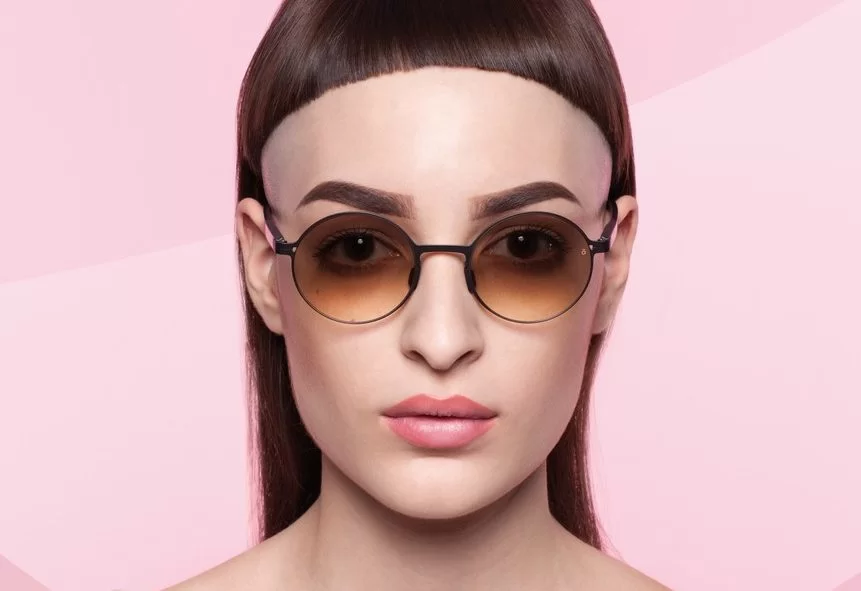 Brillenmarke Götti - Frau mit extravaganter Frisur trägt runde Sonnenbrille