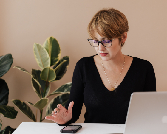 Arbeitsplatzbrille - Frau trägt Arbeitsplatzbrille und guckt auf Smartphone