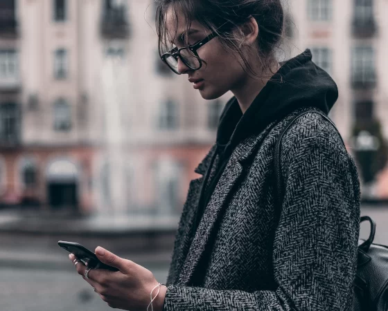 Relaxbrillen - Fernbrille mit nahunterstützenden Active-Gläsern, Frau mit Smartphone und Mantel