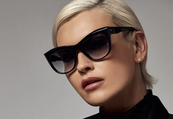 Brillenmarke Dita Eyewear - Blonde Frau mit Sonnenbrille, schwarzer Rahmen