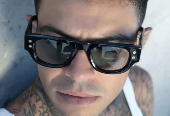 Brillenmarke Dita Eyewear - Mann mit Tattoos und Sonnenbrille in Tank Top