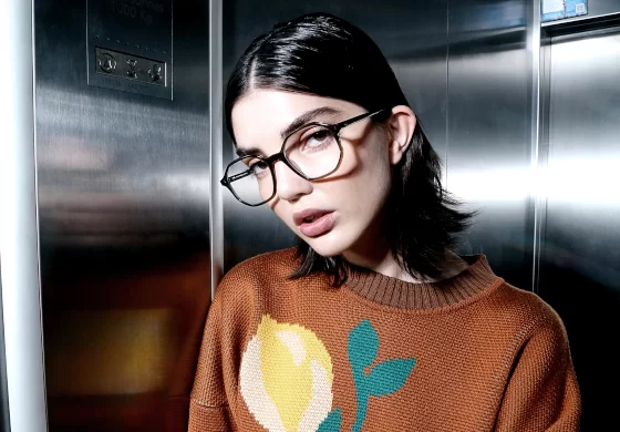 Peter and May Brillen - Frau mit Pullover und viel gel in den haaren trägt riesige Brille